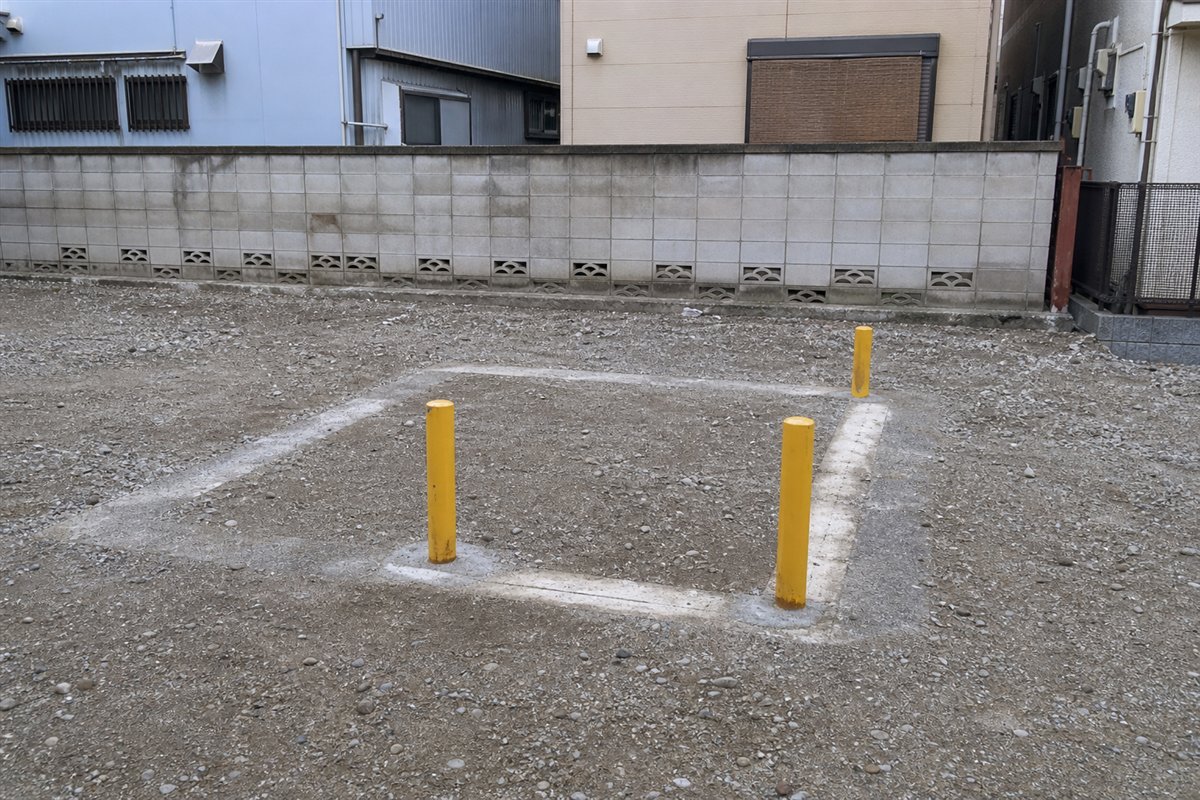 建物角を保護していた黄色い車止めポール三本だけが、何もない敷地の中央近くに整然と残っている