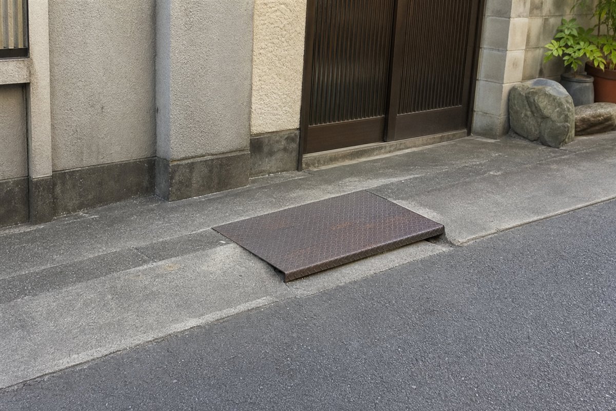 側溝はコンクリートで平らに埋められたが、玄関へ渡るための短い縞鋼板だけが少し盛り上がって残る